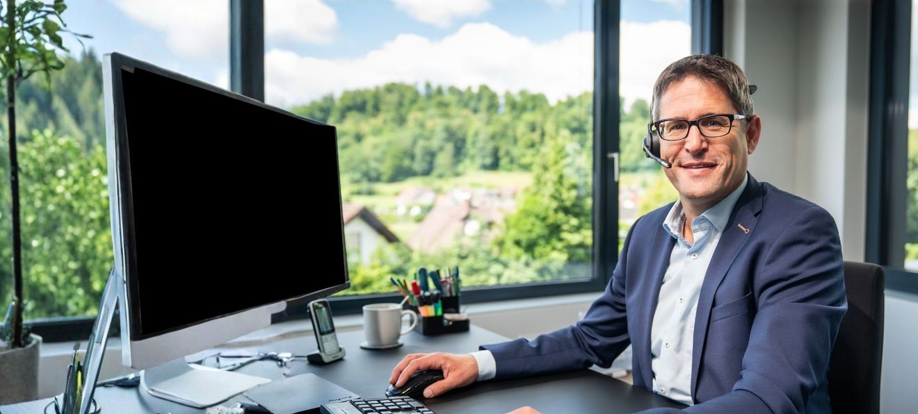 Mann mit Headset am Schreibtisch sitzend