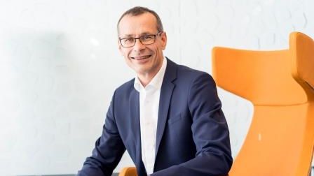 Geschäftsführer Bernhard Palm sitzend in einem orangenem Stuhl 