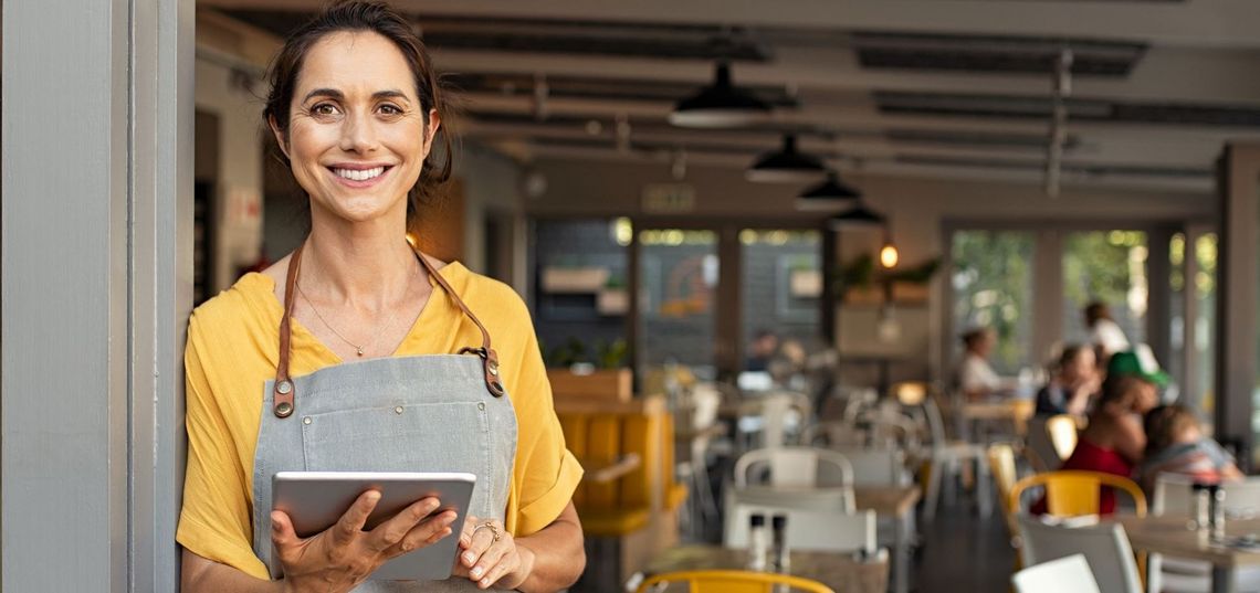 Mann mit Laptop sitzend auf einem orangenen Stuhl 