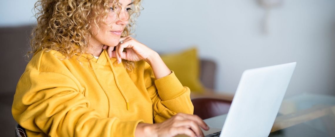 Frau mit Laptop am Tisch sitzend