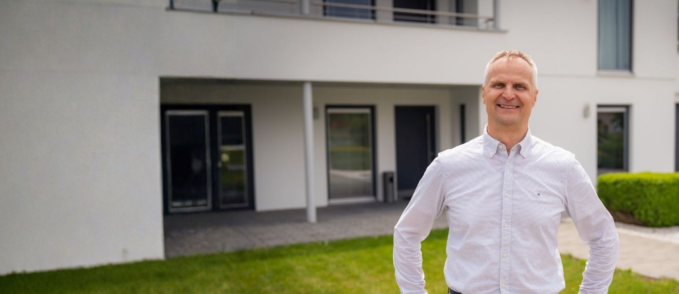 Mann stehend vor einem Haus