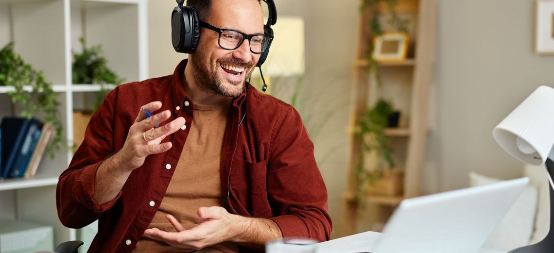 Mann am Telefon vor dem Laptop sitzend im Büro