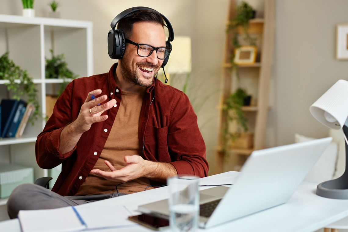 Mann am Telefon vor dem Laptop sitzend im Büro