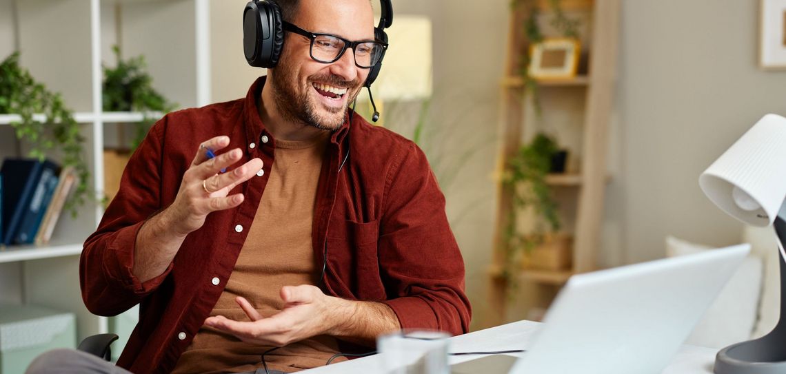 Mann am Telefon vor dem Laptop sitzend im Büro