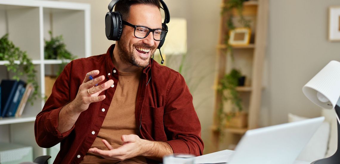 Mann am Telefon vor dem Laptop sitzend im Büro