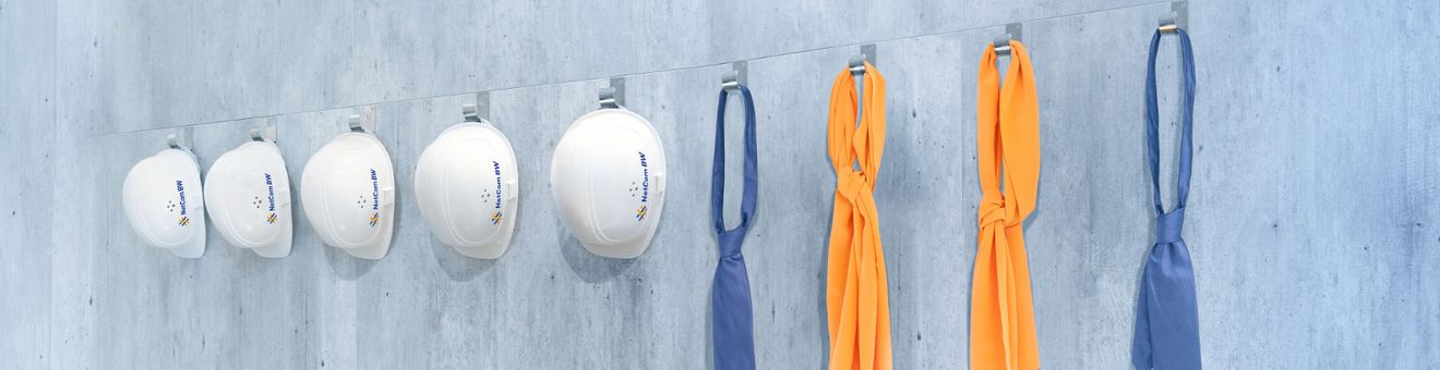 Helme und Krawatten an einer Wand aufgehängt 