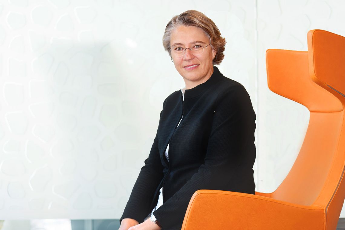 Dr. Silvia Schick auf einem orangenem Stuhl sitzend 