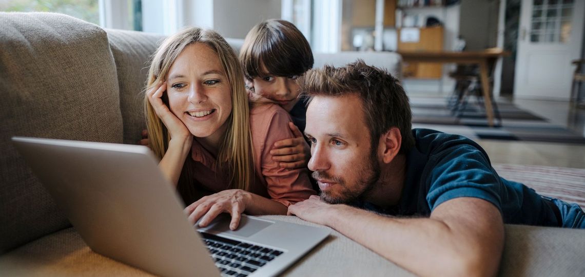 Familie im Wohnzimmer am Laptop