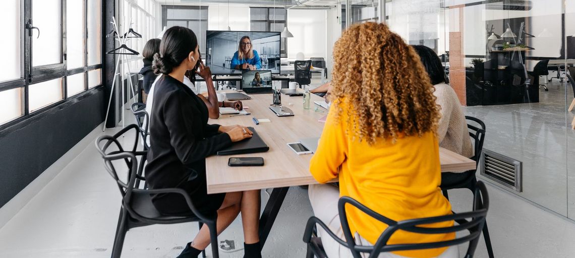 Geschäftsmeeting am Tisch sitzend drei Männer und drei Frauen