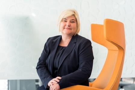 Tanja Zahn-Kammerer auf einem orangenem Stuhl sitzend 